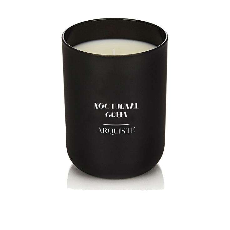 Black candle with 'Nocturnal Green Arquiste' branding on a white background