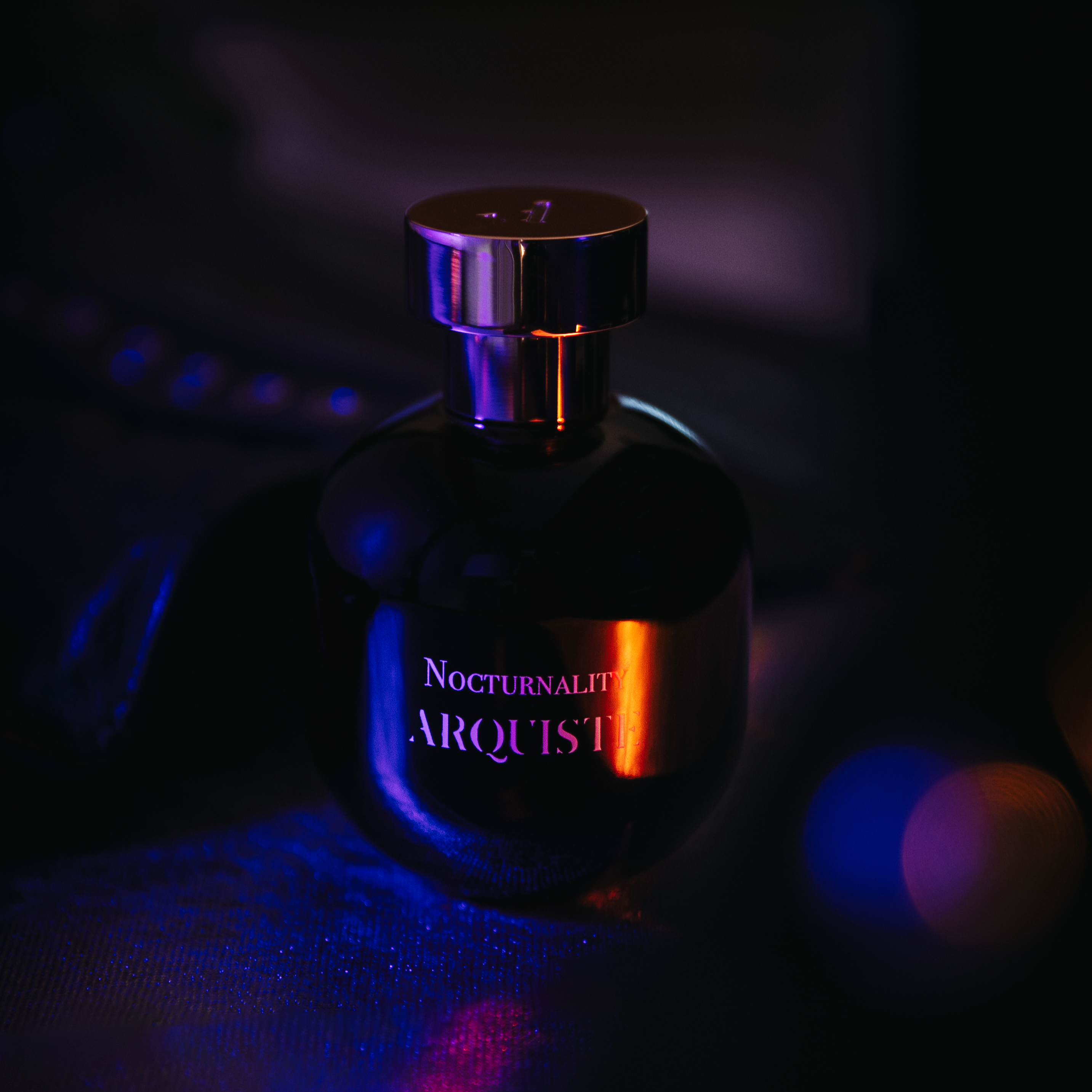 Perfume bottle with 'Nocturnality' and 'Arquiste' text in a dark setting