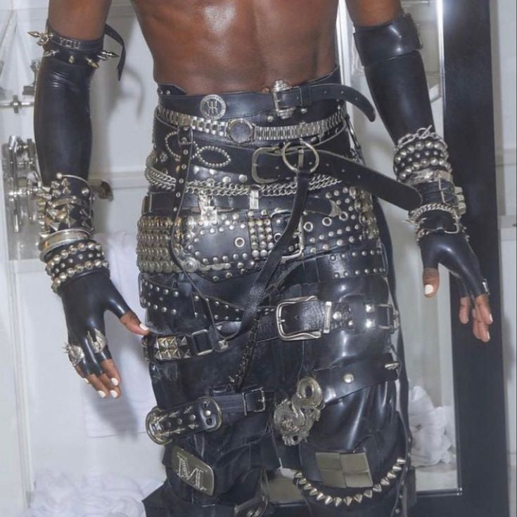 Person wearing a detailed black leather outfit with metal buckles and accessories.