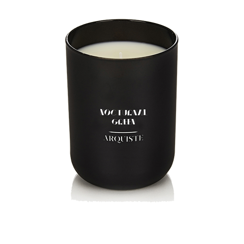 Black candle with 'Nocturnal Green Arquiste' branding on a white background