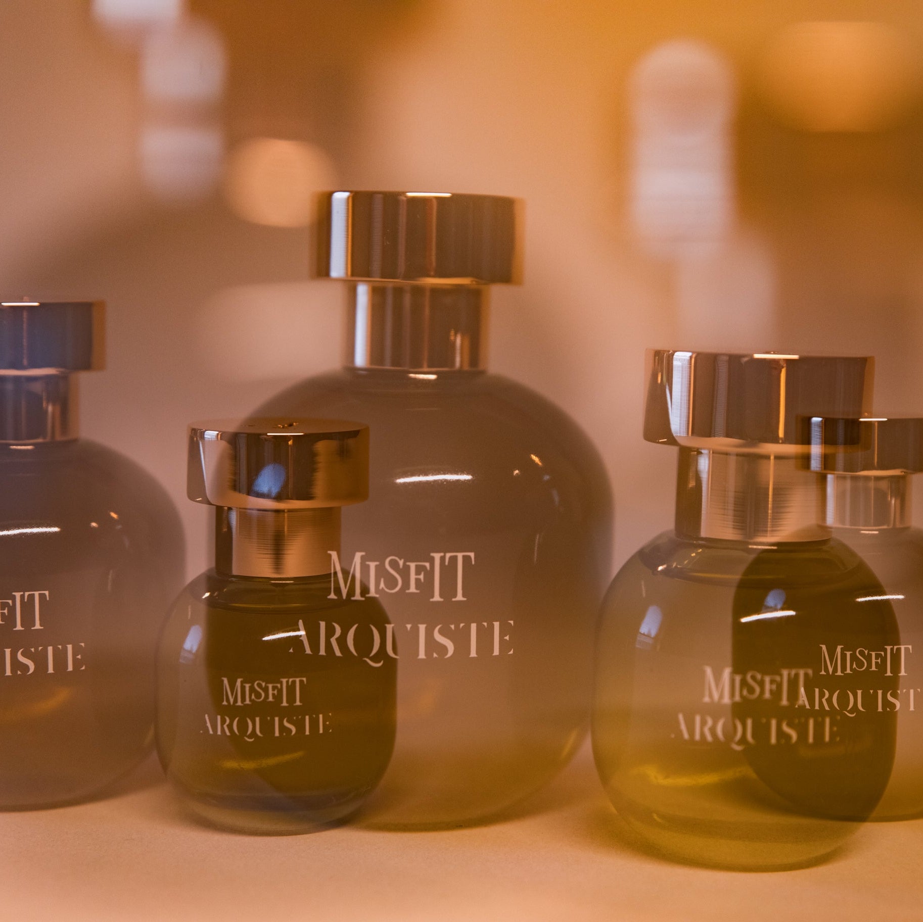 Set of Misfit Arquiste perfume bottles on a blurred background