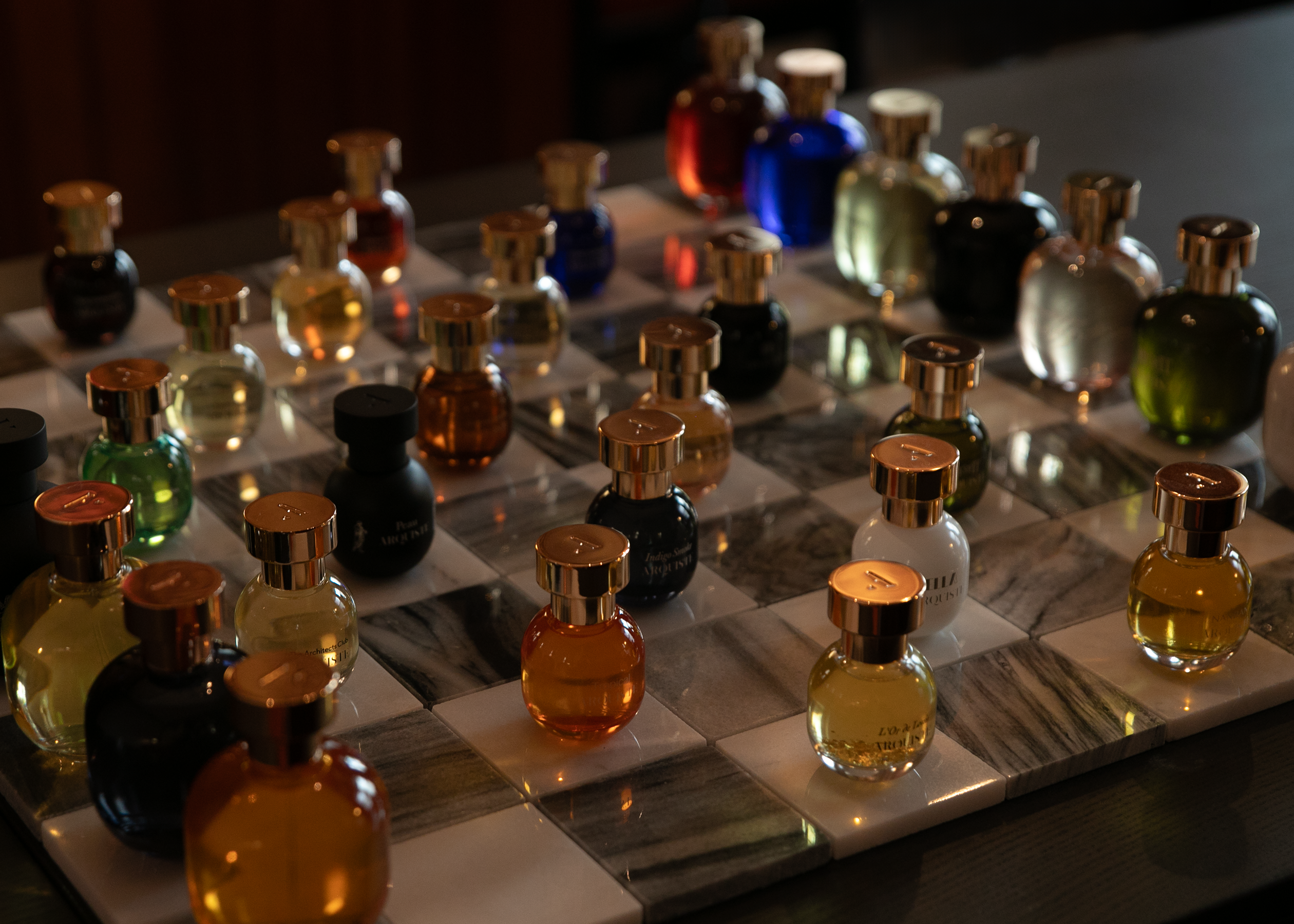 Collection of Arquiste  perfume bottles on a chessboard